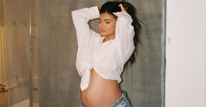 Kylie Jenner amb les mans als cabells Tancar els ulls de la part superior blanca embarassada